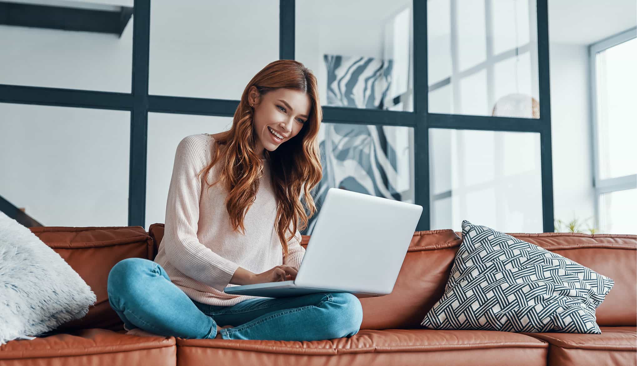 woman working on couch with laptop